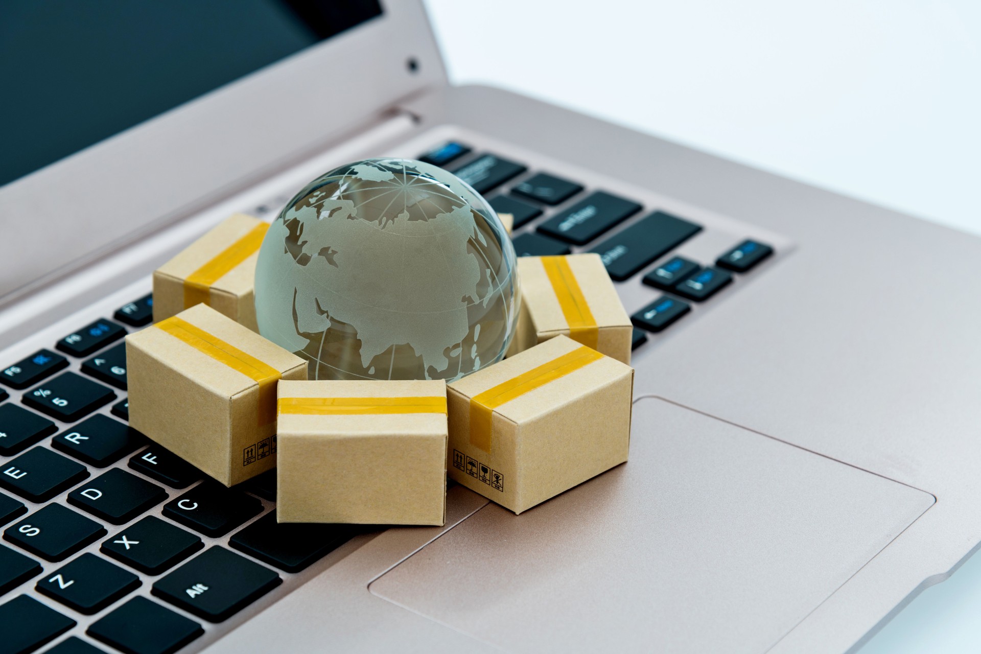 Glass globe and small boxes on laptop keyboard